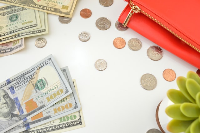 a bunch of cash and coins on a white table
